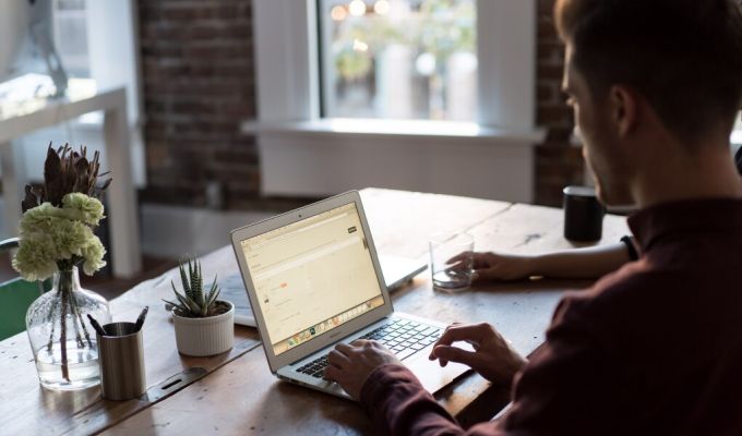 mężczyzna przegląda internet na laptopie w kuchni