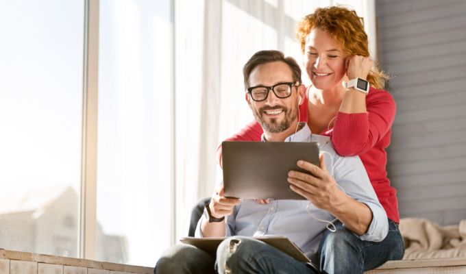 kobieta z mężczyzną patrzą w tablet